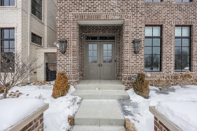 snow covered property entrance with french doors