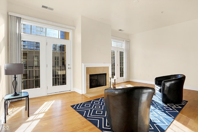 living room featuring a fireplace, wood-type flooring, and french doors