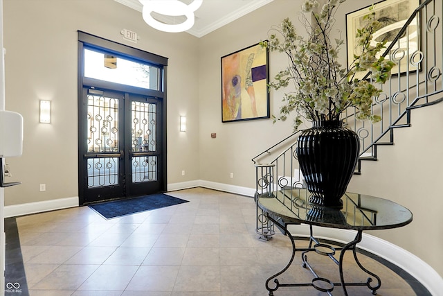 tiled entryway featuring crown molding and french doors