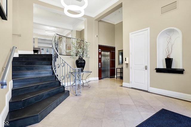 stairway featuring a notable chandelier, crown molding, and elevator