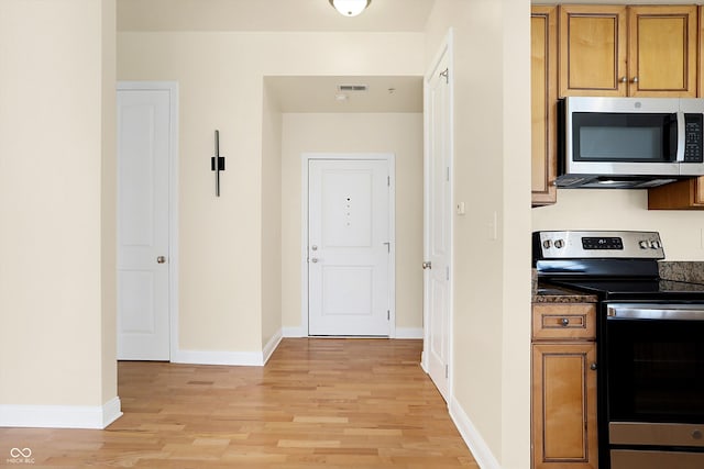 kitchen with stainless steel appliances and light hardwood / wood-style flooring