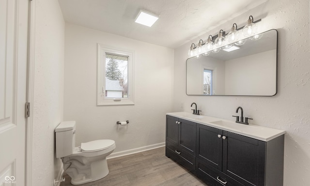 bathroom featuring vanity, a textured ceiling, hardwood / wood-style flooring, and toilet