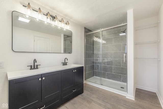 bathroom with vanity, hardwood / wood-style flooring, and a shower with shower door