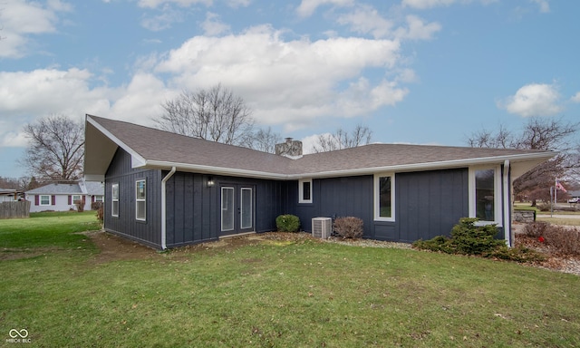 rear view of house featuring a yard and central air condition unit