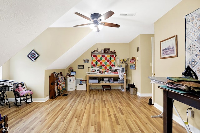 playroom featuring lofted ceiling, ceiling fan, a textured ceiling, and light wood-type flooring