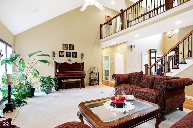 living room with light carpet, ceiling fan with notable chandelier, and high vaulted ceiling