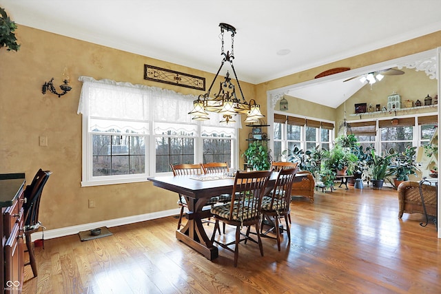 dining space with hardwood / wood-style flooring, ceiling fan, and vaulted ceiling