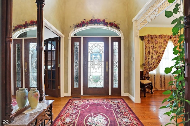 foyer entrance featuring crown molding and light hardwood / wood-style floors