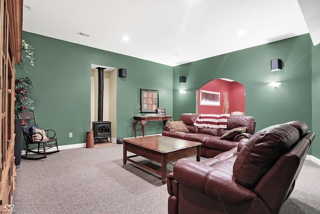 living room featuring light colored carpet and a wood stove