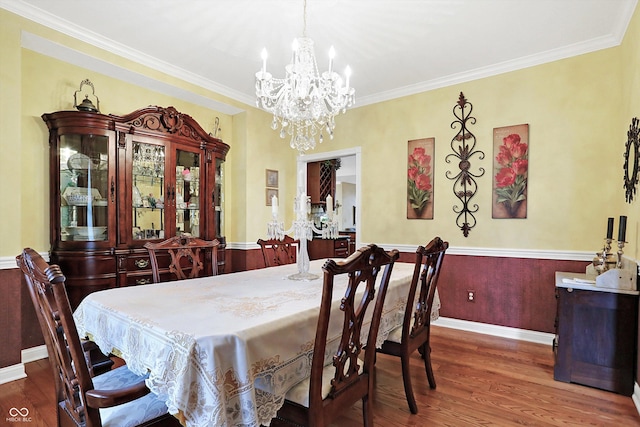 dining space with a chandelier, dark hardwood / wood-style flooring, and crown molding