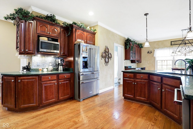 kitchen with sink, stainless steel appliances, backsplash, light hardwood / wood-style floors, and decorative light fixtures