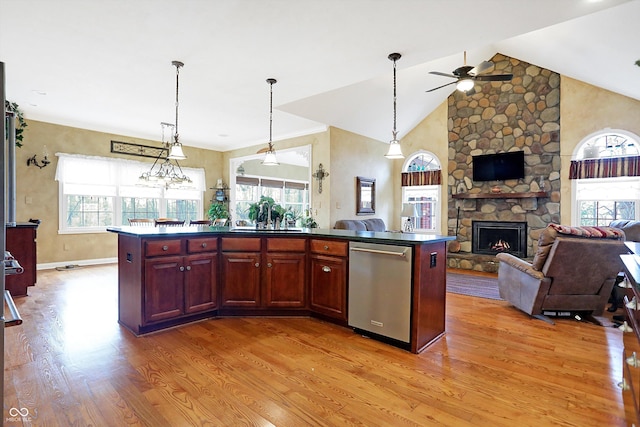 kitchen featuring a fireplace, dishwasher, a center island, and light hardwood / wood-style flooring