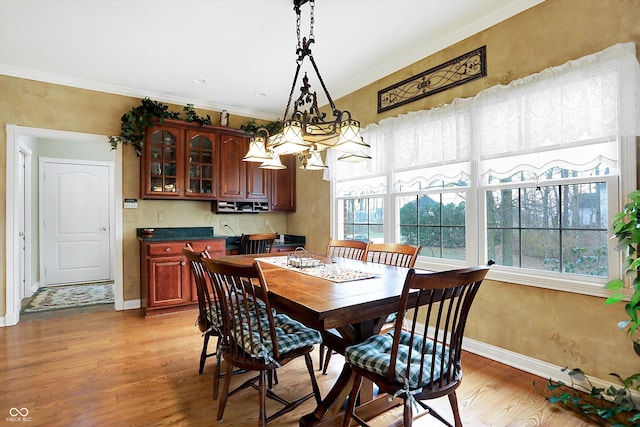 dining room with ornamental molding, a chandelier, and light wood-type flooring