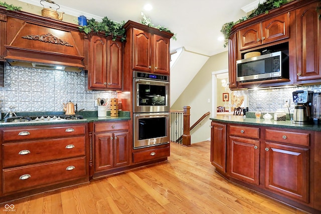 kitchen with decorative backsplash, crown molding, light wood-type flooring, and appliances with stainless steel finishes