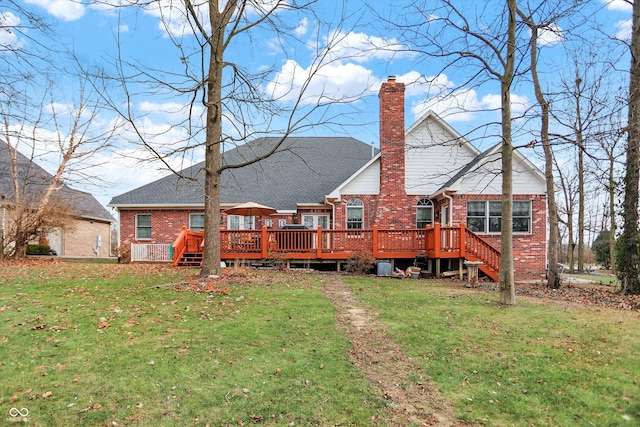 rear view of house with a wooden deck and a yard