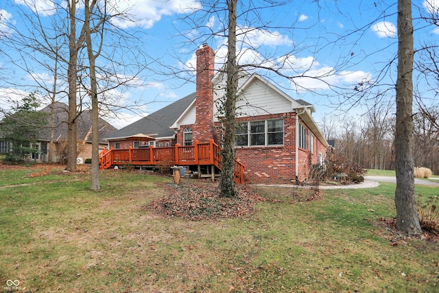 rear view of house with a deck and a lawn