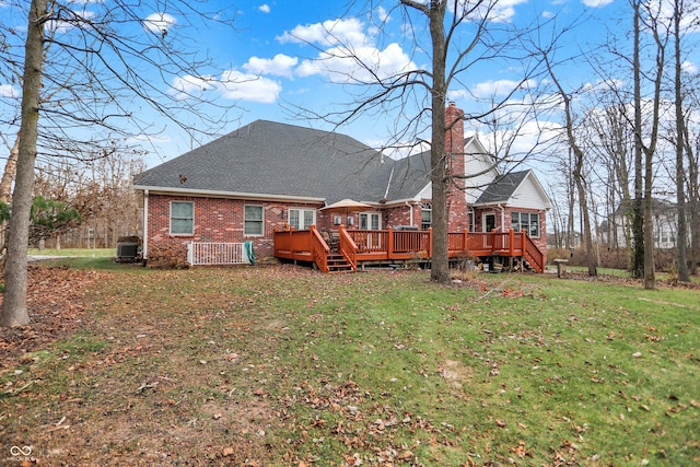 rear view of house featuring a lawn, central AC unit, and a deck