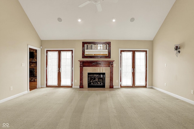unfurnished living room with a premium fireplace, baseboards, a ceiling fan, and light carpet