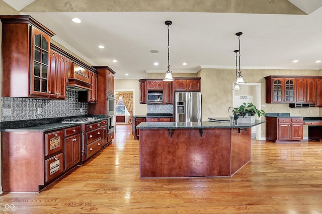 kitchen featuring a center island with sink, light wood-type flooring, dark brown cabinets, a sink, and stainless steel appliances