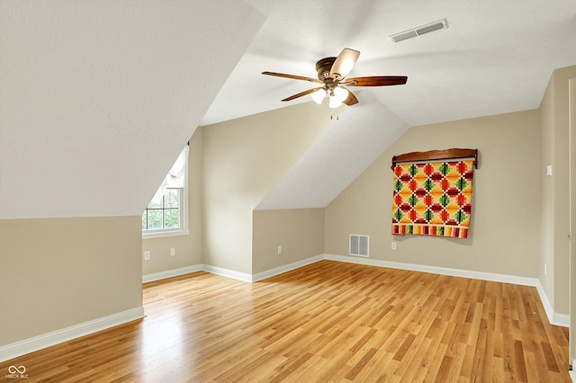 additional living space with visible vents, a ceiling fan, light wood finished floors, and lofted ceiling