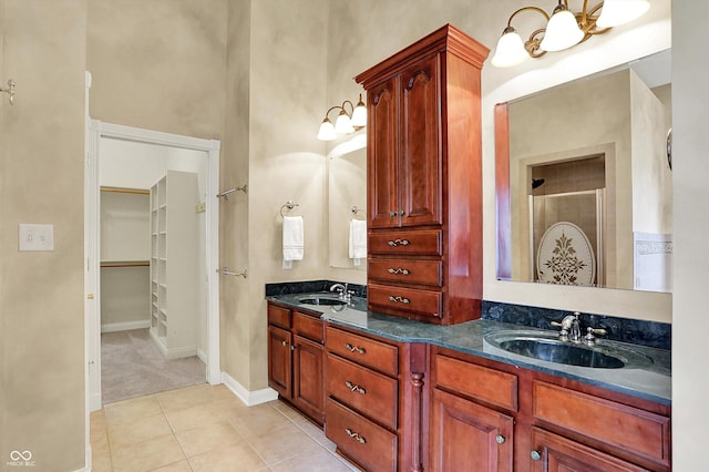 full bathroom featuring a sink, tile patterned floors, an inviting chandelier, and double vanity