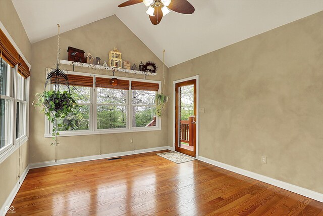 unfurnished room with ceiling fan, visible vents, wood finished floors, and high vaulted ceiling