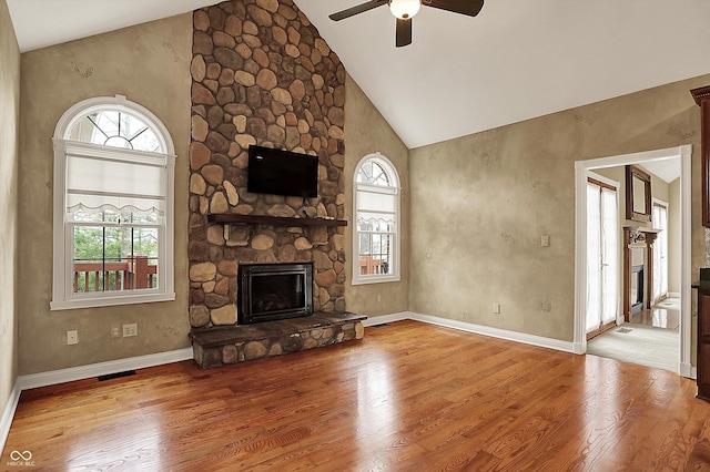 unfurnished living room with plenty of natural light, a ceiling fan, wood finished floors, and a fireplace