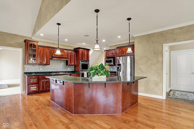 kitchen featuring stainless steel appliances, baseboards, an island with sink, and light wood-type flooring