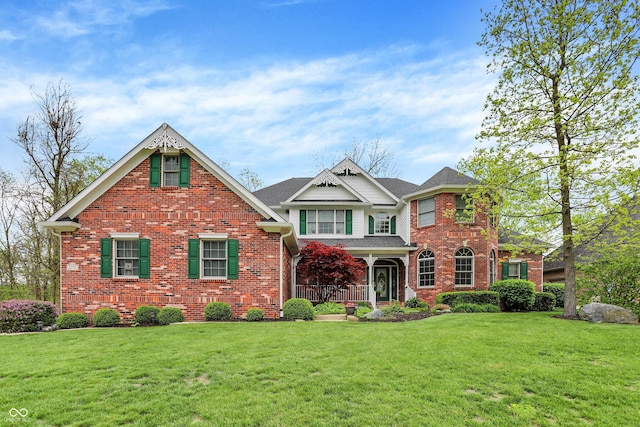 craftsman-style house featuring brick siding and a front yard