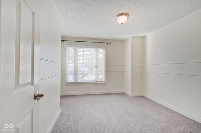 carpeted spare room with a textured ceiling