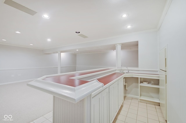 kitchen with kitchen peninsula, crown molding, white refrigerator, white cabinetry, and light tile patterned flooring