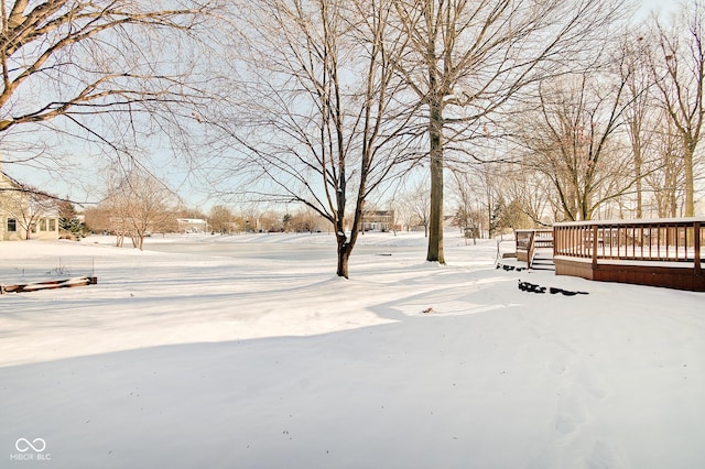 yard covered in snow with a deck