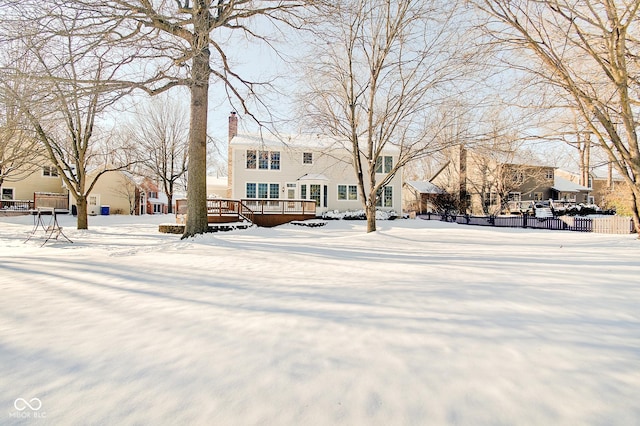 yard layered in snow with a wooden deck