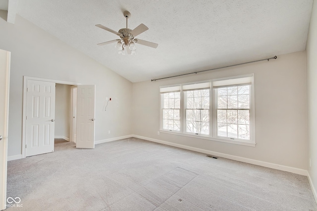 carpeted empty room featuring ceiling fan, high vaulted ceiling, and a textured ceiling