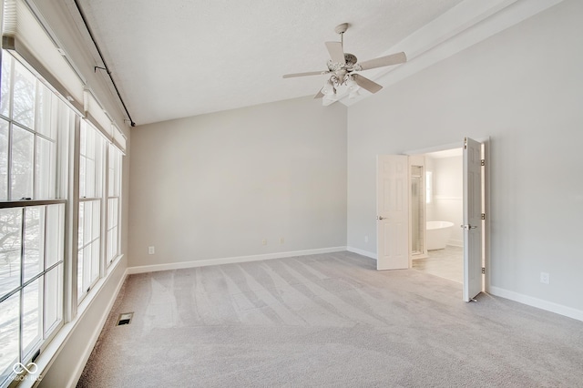 carpeted empty room featuring ceiling fan and lofted ceiling