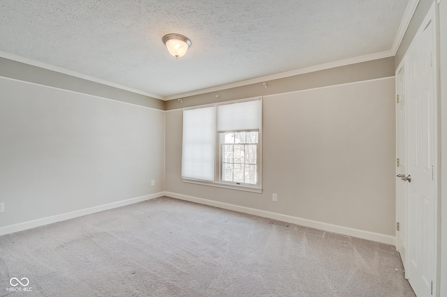 carpeted empty room with ornamental molding and a textured ceiling