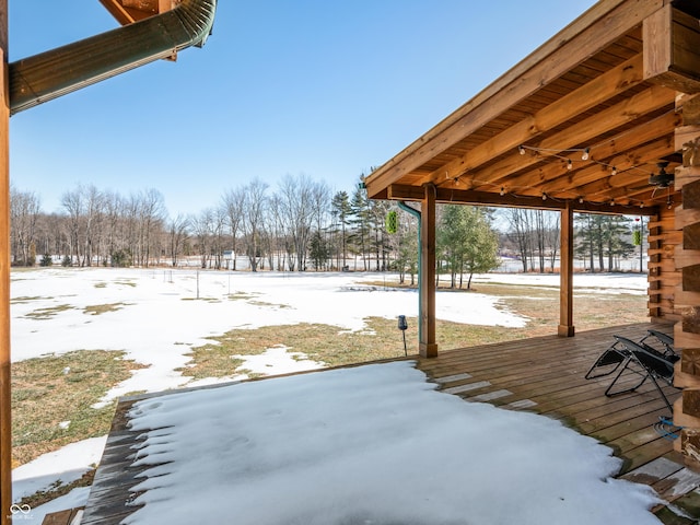 snowy yard featuring a wooden deck