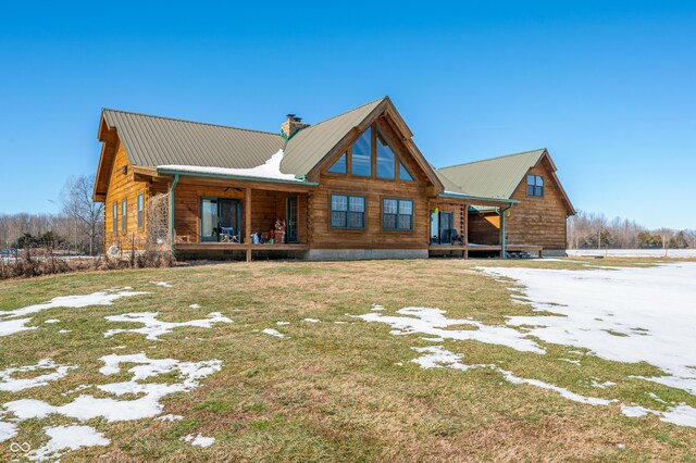 back of property with a yard and covered porch