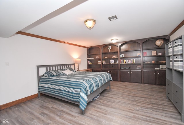 bedroom with hardwood / wood-style floors and ornamental molding