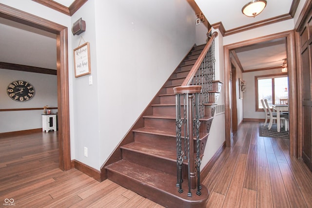 staircase featuring hardwood / wood-style flooring and crown molding