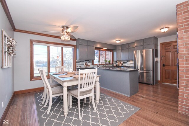 dining room with ceiling fan, dark hardwood / wood-style flooring, and crown molding