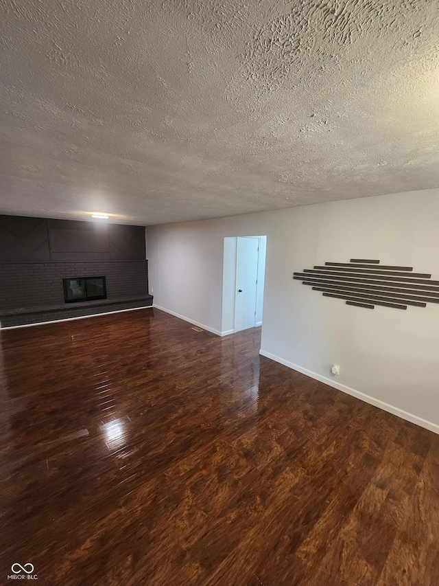 unfurnished living room featuring a textured ceiling, wood-type flooring, and a fireplace