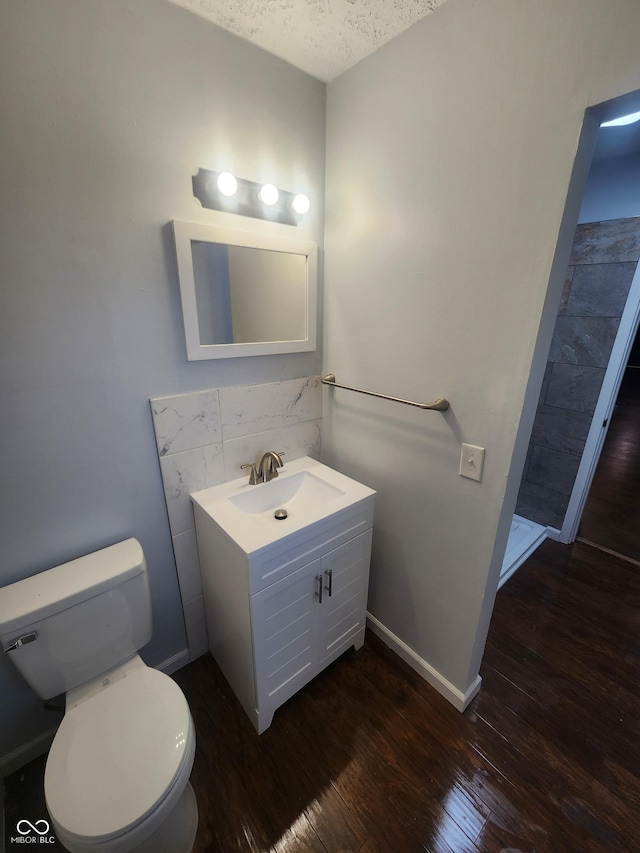 bathroom featuring vanity, hardwood / wood-style floors, a textured ceiling, and toilet