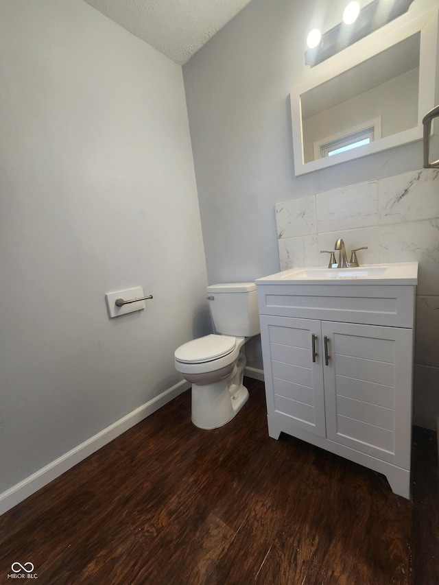 bathroom with toilet, vanity, a textured ceiling, and hardwood / wood-style flooring