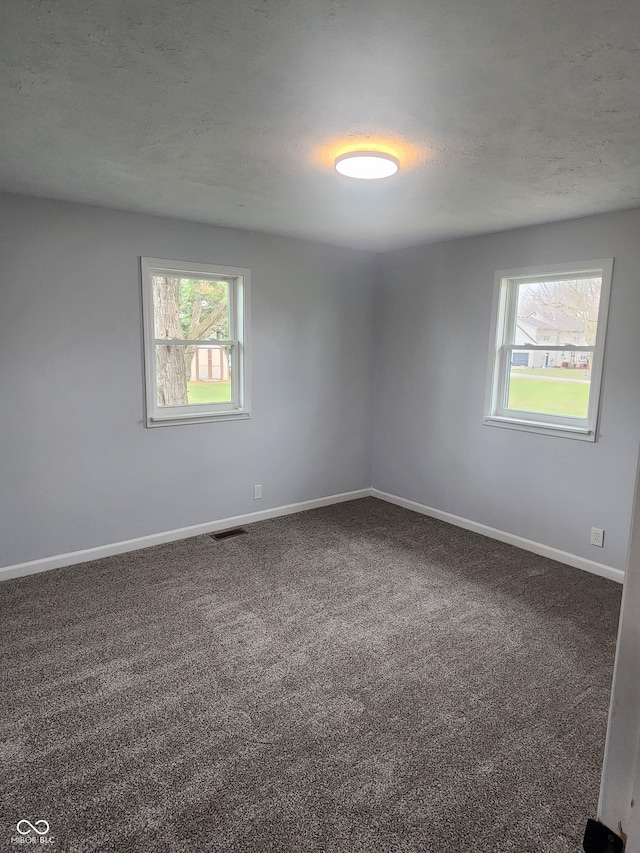 carpeted spare room with a textured ceiling