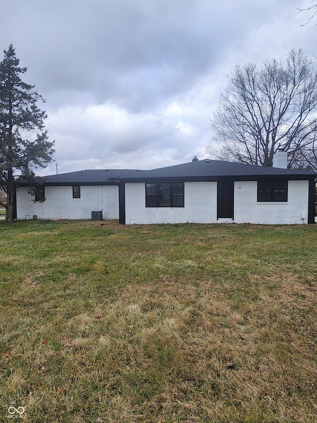 rear view of house featuring a yard and central AC unit