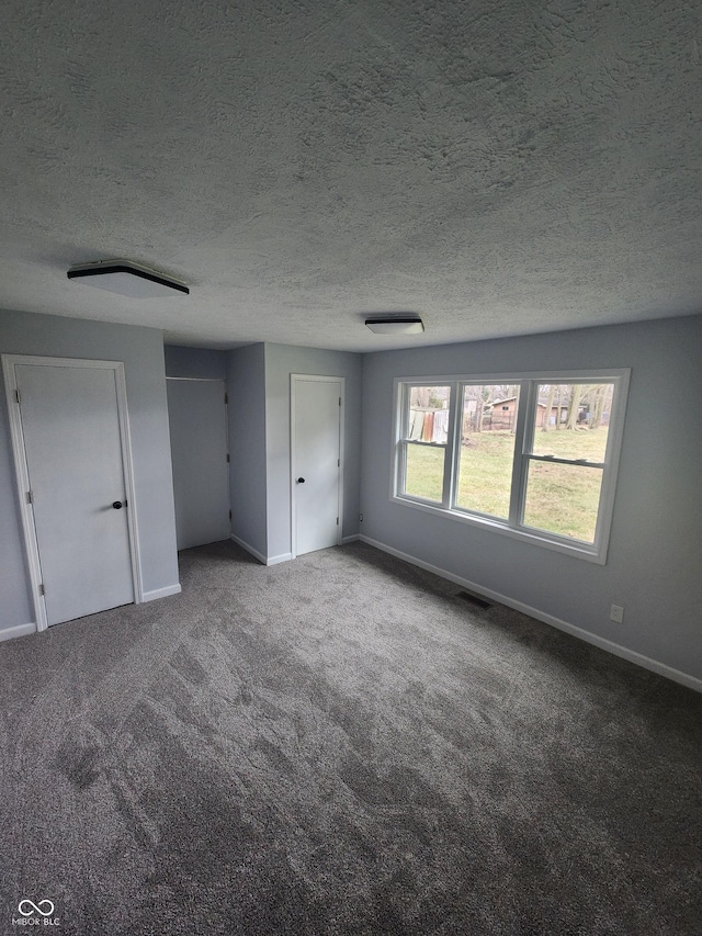 unfurnished bedroom with carpet floors and a textured ceiling