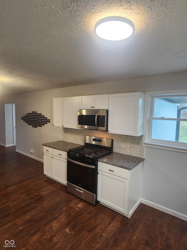 kitchen featuring white cabinets, dark hardwood / wood-style floors, backsplash, and appliances with stainless steel finishes