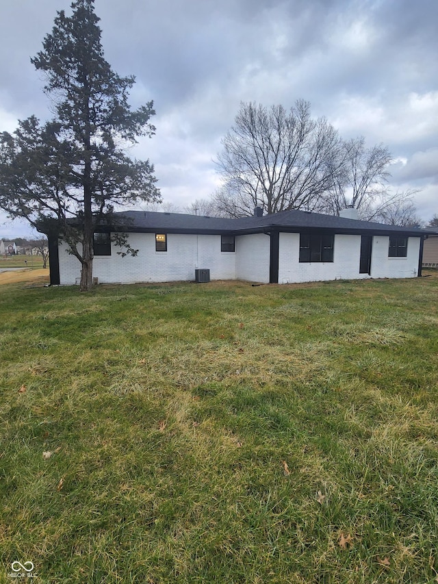 rear view of property with a yard and central AC unit