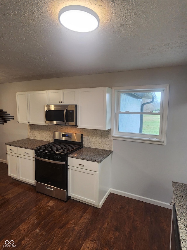 kitchen featuring white cabinets, dark hardwood / wood-style flooring, stainless steel appliances, and a textured ceiling